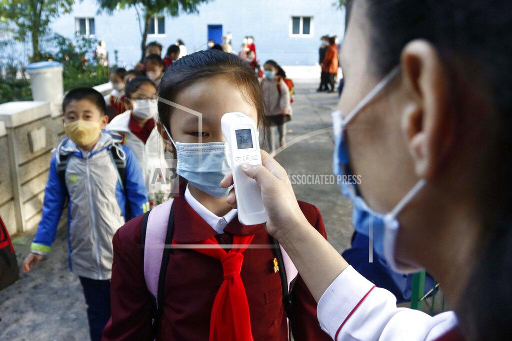 Cha Song Ho FILE - A teacher takes the body temperature of a schoolgirl to help curb the spread of the coronavirus before entering Kim Song Ju Primary School in Central District in Pyongyang, North Korea, Wednesday, Oct. 13, 2021. Before acknowledging domestic COVID-19 cases, Thursday, May 12, 2022, North Korea spent 2 1/2 years rejecting outside offers of vaccines and steadfastly claiming that its superior socialist system was protecting its 26 million people from “a malicious virus” that had killed millions around the world. (AP Photo/Cha Song Ho, File)