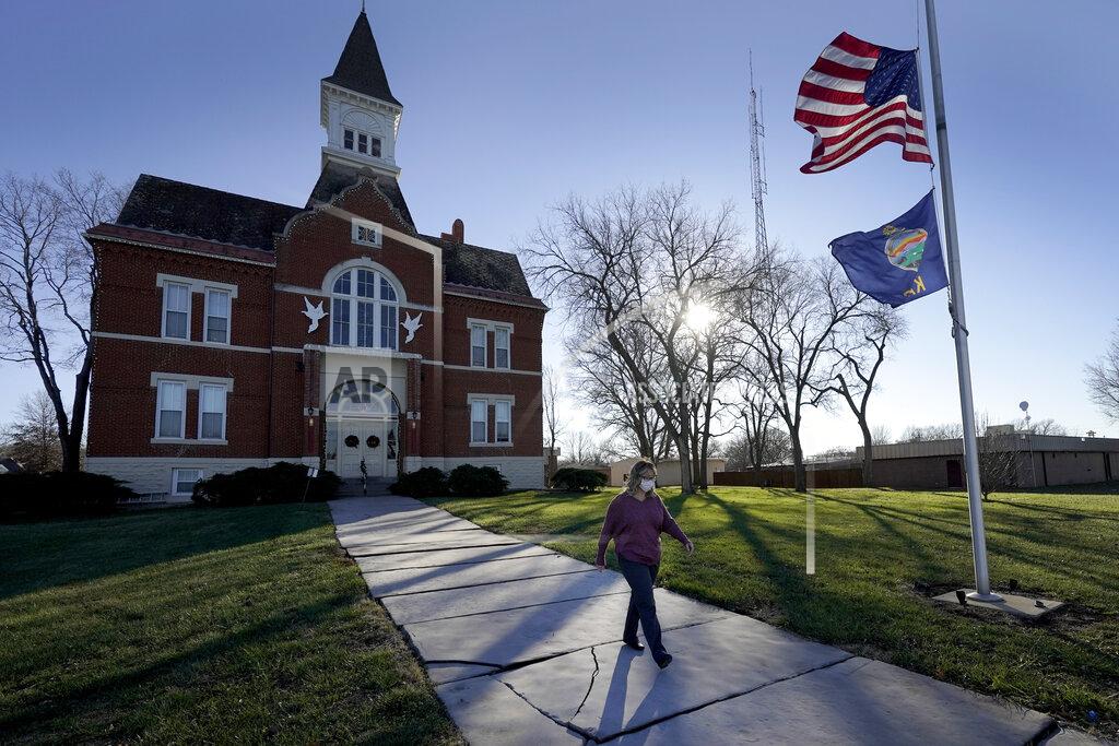 Charlie Riedel Tisha Coleman, public health administrator for Linn County, walks past the Linn County courthouse in Mound City, Kan., Monday, Dec. 7, 2020. In this community with no hospital, she's failed to persuade her neighbors to wear masks and take precautions against COVID-19, even as cases rise. In return, she's been harassed, sued, vilified and called a Democrat, an insult in her circles. (AP Photo/Charlie Riedel)