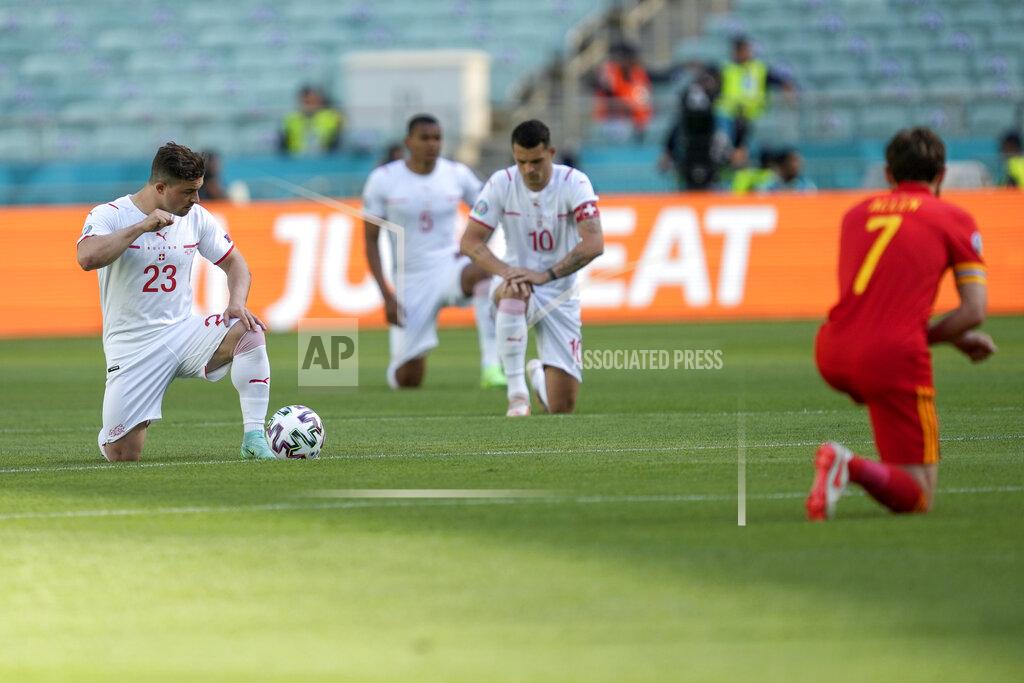 Darko Vojinovic Switzerland's Xherdan Shaqiri, left, and players take the knee prior to the Euro 2020 soccer championship group A match between Wales and Switzerland, at the Baku Olympic stadium, in Baku, Azerbaijan, Saturday, June 12, 2021. (AP Photo/Darko Vojinovic, Pool)