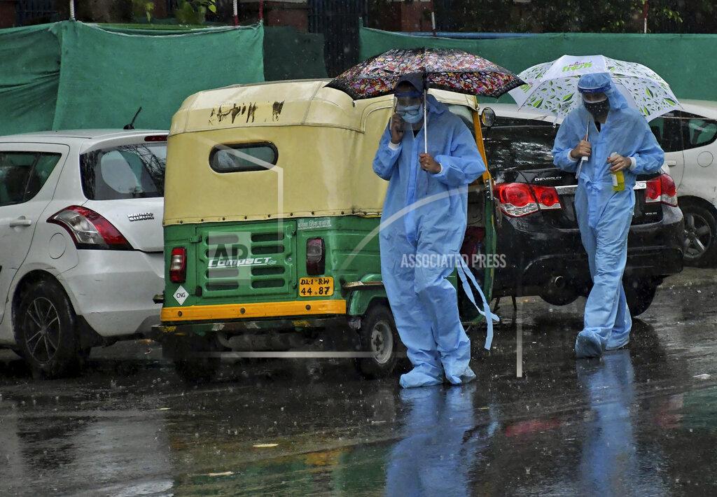 Ishant Chauhan Paramedics wearing PPE suits carry umbrellas as they walk inside a hospital premises during heavy rain in New Delhi, India, Wednesday, May 19, 2021. India recorded the pandemic's highest single-day death toll in the world on Wednesday, as coronavirus infections continued to spread through its vast rural areas with weak health systems. (AP Photo/Ishant Chauhan)