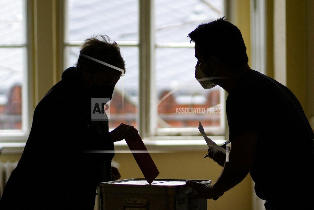 Markus Schreiber A woman casts her vote at a pooling station for postal voting for Sunday's German national election in Berlin, Germany, Thursday, Sept. 23, 2021. On Sunday Sept. 26 Germany will elect a new parliament. (AP Photo/Markus Schreiber)