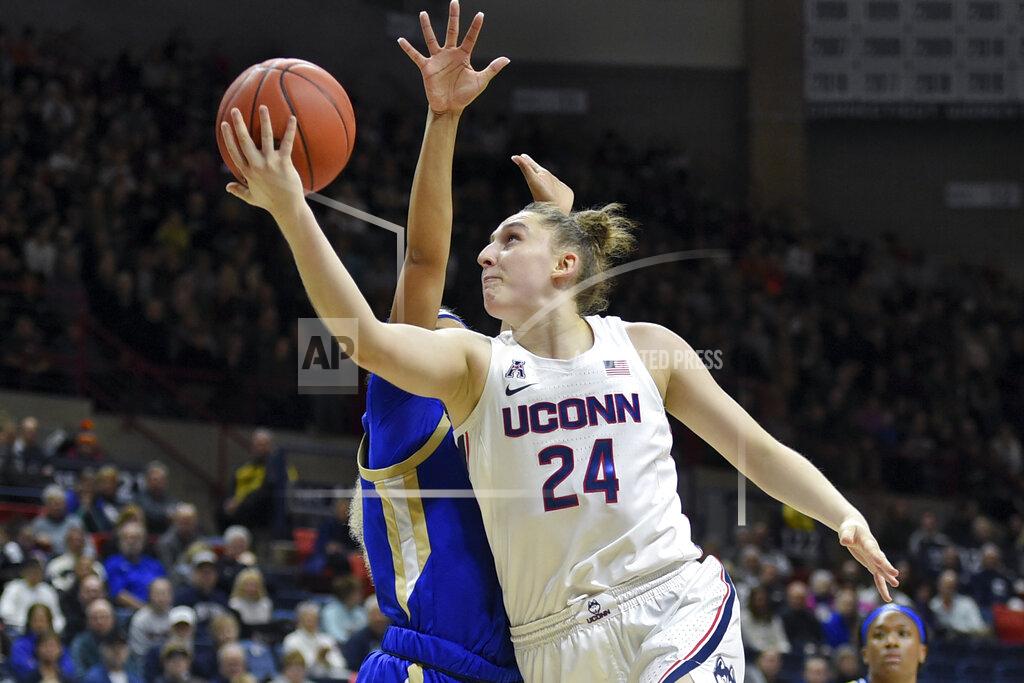 Stephen Dunn FILE - In this Sunday, Jan. 19, 2020, file photo, Connecticut's Anna Makurat (24) shoots during the first half of an NCAA college basketball game against Tulsa, in Storrs, Conn. All but one of Anna Makurat's teammates headed home after the NCAA canceled this year's postseason basketball tournament and the school suspended classes amid the COVID-19 pandemic. For the 19-year-old UConn freshman from Poland, the decision was not that easy, especially with ever-increasing travel restrictions to and from Europe. She worried about classes restarting while she was overseas and when — or if — she might be able to get back to campus. (AP Photo/Stephen Dunn, File)