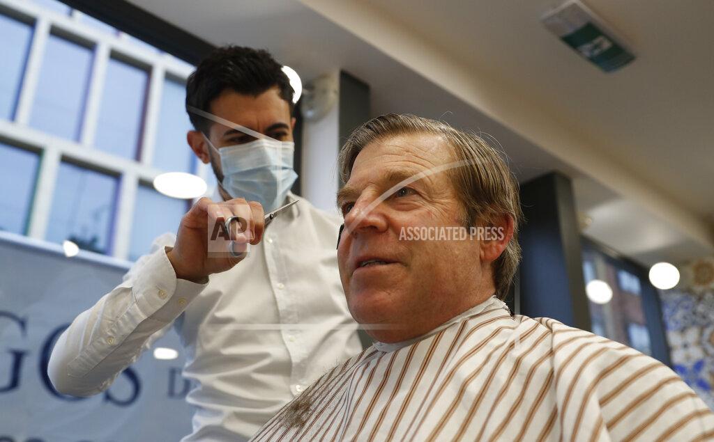 Alastair Grant The Lord Mayor of London William Russell gets his hair cut by Ali Baltar, owner of the Grooming Lounge in the City of London, Monday, April 12, 2021. Millions of people in England will get their first chance in months for haircuts, casual shopping and restaurant meals on Monday, as the government takes the next step on its lockdown-lifting road map. (AP Photo/Alastair Grant)