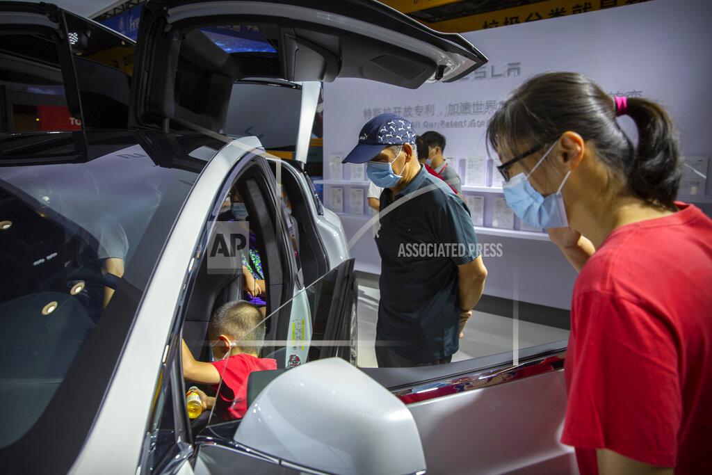 Mark Schiefelbein Visitors wearing face masks to protect against the coronavirus look at a Tesla vehicle on display at the China International Fair for Trade in Services (CIFTIS) in Beijing, Saturday, Sept. 5, 2020. Auto executives are flying in early to wait out a coronavirus quarantine ahead of the Beijing auto show, the year's biggest sales event for a global industry that is struggling with tumbling sales and layoffs. Organizers say they will impose intensive anti-disease controls on crowds and monitor visitors and employees for signs of infection. (AP Photo/Mark Schiefelbein)