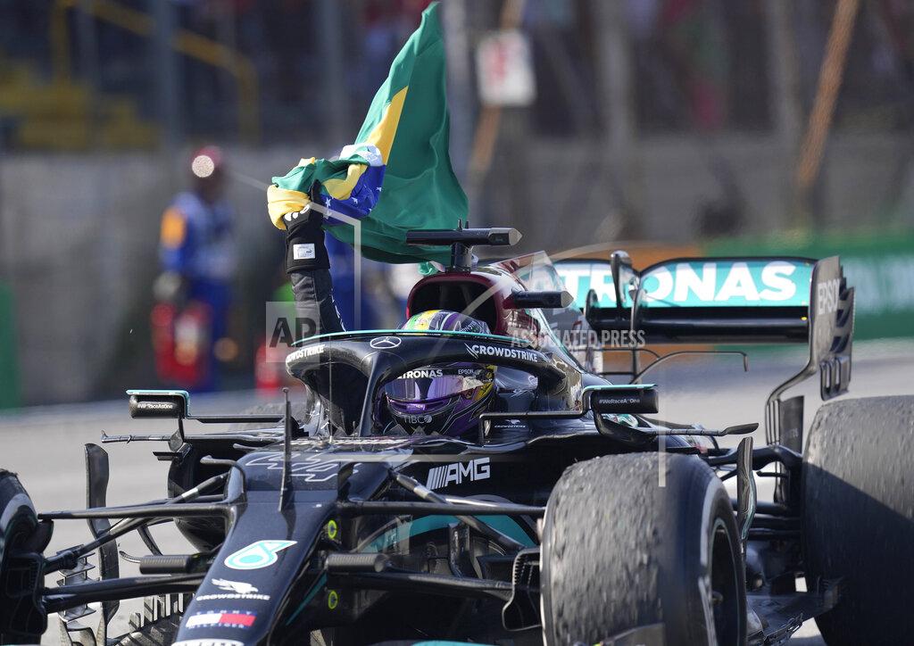 Andre Penner Mercedes' Lewis Hamilton holds a Brazilian flag as he celebrates wining the Brazilian Formula One Grand Prix at the Interlagos race track in Sao Paulo, Brazil, Sunday, Nov. 14, 2021. (AP Photo/Andre Penner)