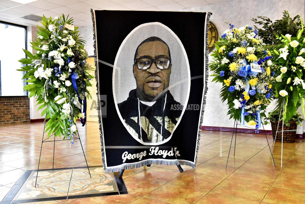 Ed Clemente A picture of George Floyd and flowers are set up for a memorial service for Floyd, Saturday, June 6, 2020, in Raeford, N.C. Floyd died after being restrained by Minneapolis police officers on May 25. (Ed Clemente/The Fayetteville Observer via AP, Pool)