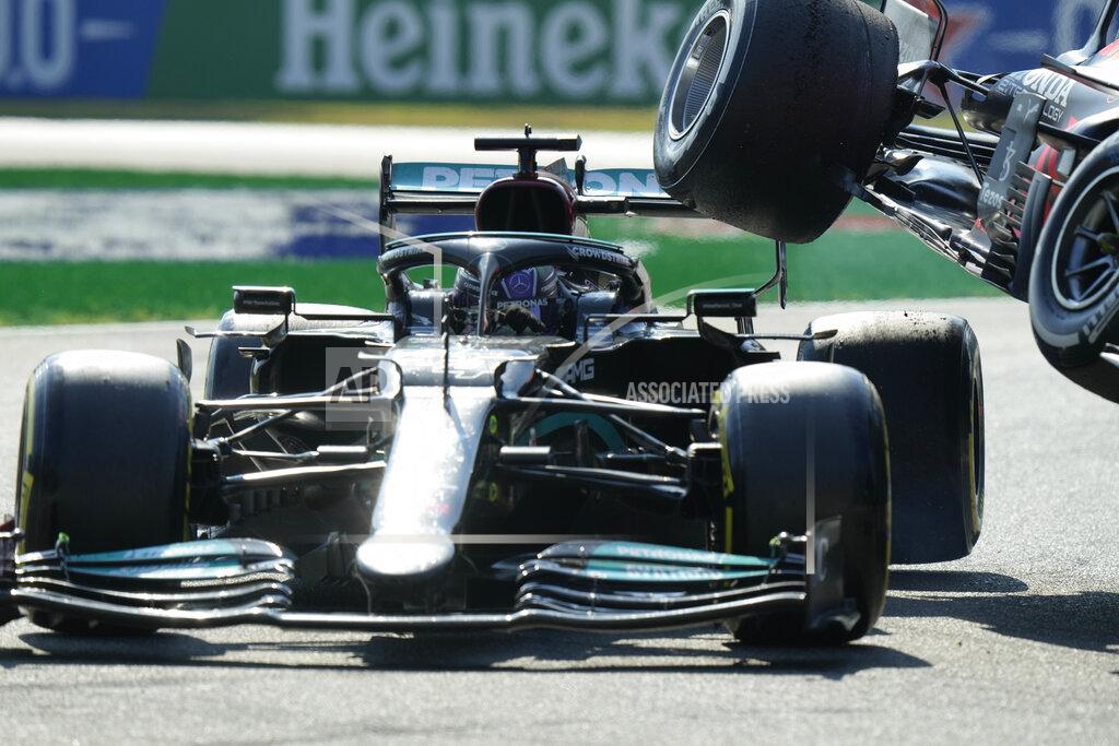Luca Bruno Mercedes driver Lewis Hamilton of Britain crashes with Red Bull driver Max Verstappen of the Netherlands during the Italian Formula One Grand Prix, at Monza racetrack, in Monza, Italy, Sunday, Sept.12, 2021. (AP Photo/Luca Bruno)