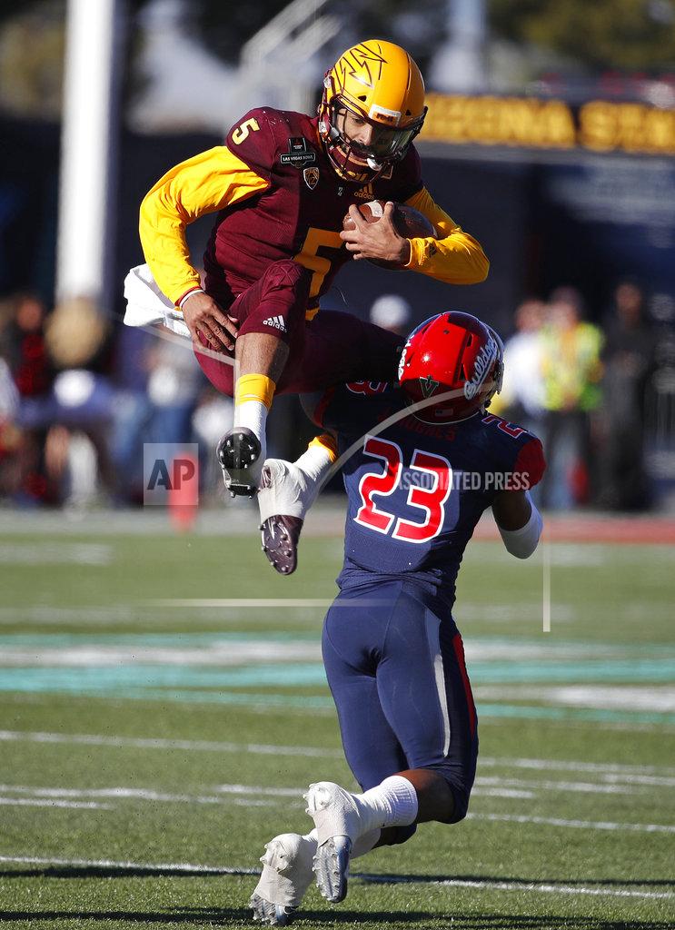 John Locher Arizona State quarterback Manny Wilkins jumps over Fresno State defensive back Juju Hughes (23) during the first half of the Las Vegas Bowl NCAA college football game, Saturday, Dec. 15, 2018, in Las Vegas. (AP Photo/John Locher)