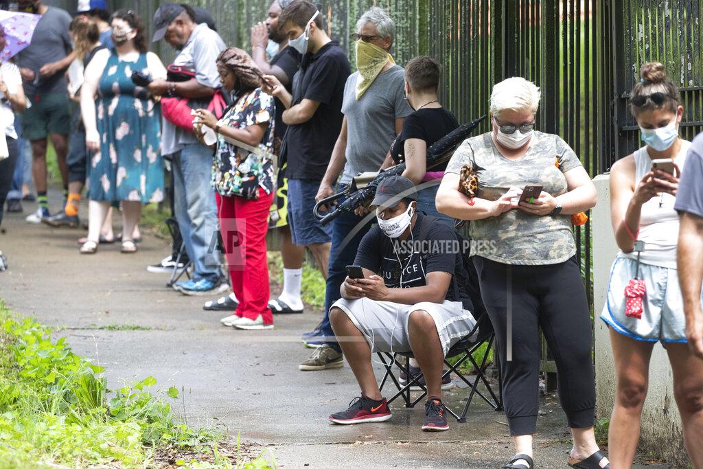 John Bazemore Steven Posey checks his phone as he waits in line to vote, Tuesday, June 9, 2020, at Central Park in Atlanta. Voters reported wait times of three hours. (AP Photo/John Bazemore)