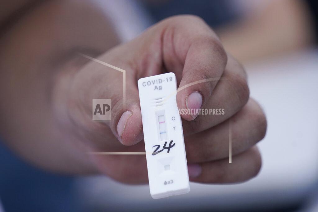 Marta Lavandier EMS technician Emmanuel Orrego shows a COVID-19 positive test strip, Monday, July 26, 2021, in Miami. More than 73,000 new coronavirus cases were reported in Florida over the previous week, according to the state health department, nearly seven times the 12,000 reported a month ago.(AP Photo/Marta Lavandier)