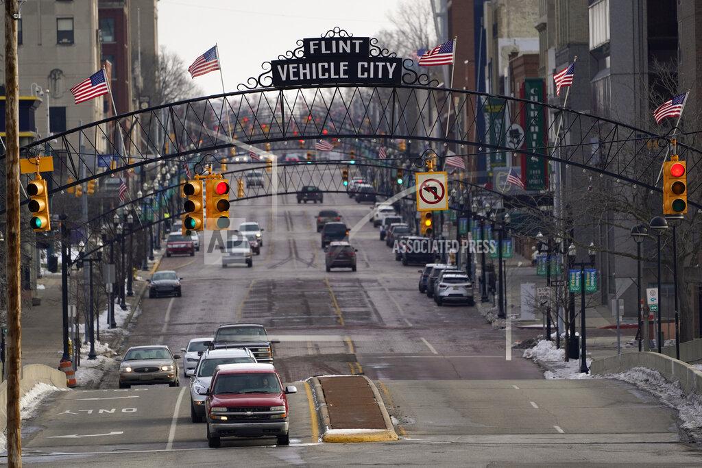 Paul Sancya Vehicles drive through downtown Flint, Mich., Wednesday, Jan. 13, 2021. Some Flint residents impacted by months of lead-tainted water are looking past expected charges against former Gov. Rick Snyder and others in his administration to healing physical and emotional damages left by the crisis. (AP Photo/Paul Sancya)