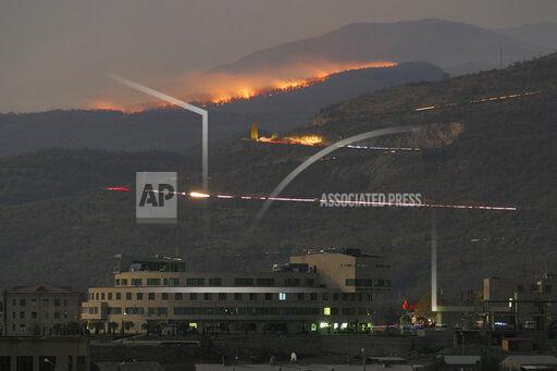 FILE - In this Saturday, Oct. 31, 2020 file photo, forest burns in the mountains after shelling by Azerbaijan's artillery during a military conflict outside Stepanakert, the separatist region of Nagorno-Karabakh. Armenia accused neighboring Azerbaijan of systematically promoting ethnic hatred against Armenia citizens, as the two nations that fought a six-week war last year faced off at a United Nations court on Thursday Oct. 14, 2021. (AP Photo/File)