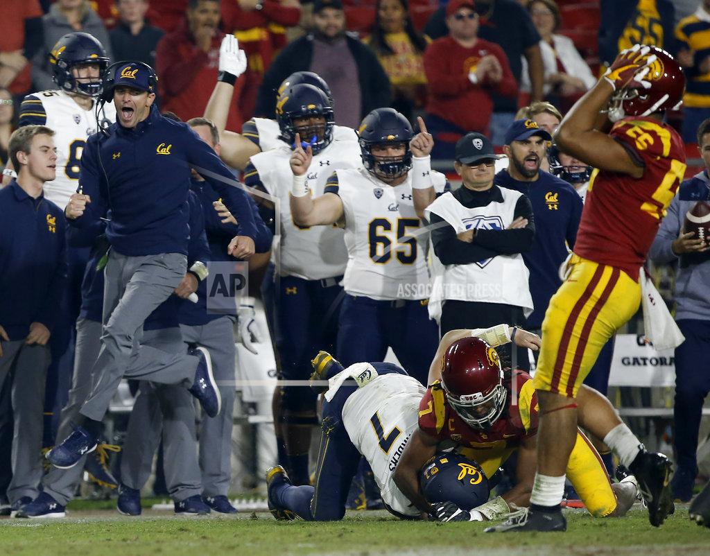 Alex Gallardo CAPTION CORRECTION: CORRECTS GAME ACTION: California head coach Justin Wilcox, left, leaps to celebrate what he thought was a first down by quarterback Chase Garbers, center, tackled by Southern California safety Marvell Tell III, second from right, as linebacker Jordan Iosefa, right, laments, but after a video replay it was determined not a first down during the second half of an NCAA college football game in Los Angeles, Saturday, Nov. 10, 2018. Instead, California ran on fourth-and-one for a first down and won 15-14. (AP Photo/Alex Gallardo)