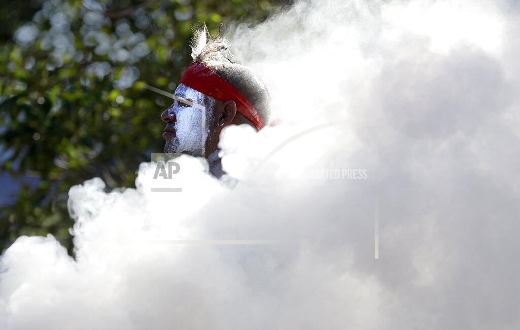 Rick Rycroft Russell Dawson of the Koomurri Aboriginal Dancers participates in a smoking ceremony during Australia Day ceremonies in Sydney, Tuesday, Jan. 26, 2021. (AP Photo/Rick Rycroft)