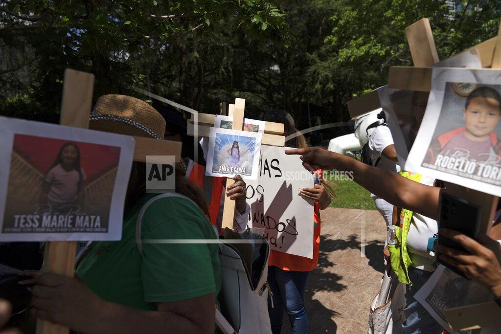Jae C. Hong Protesters carry crosses with photos of victims of the Robb Elementary School shooting in Uvalde, Texas, as they demonstrate outside the George R. Brown Convention Center where the National Rifle Association's annual meeting is held in Houston, Friday, May 27, 2022. (AP Photo/Jae C. Hong)