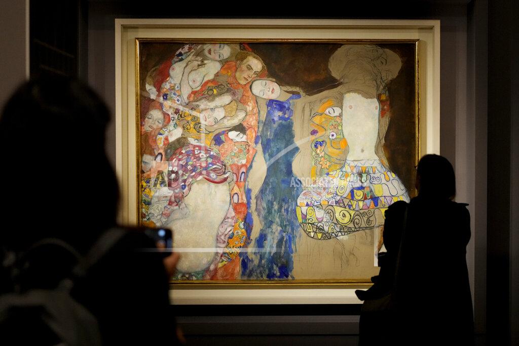Andrew Medichini People admire Gustav Klimt's oil on canvas painting "The Bride" (1918) on display at the exhibition "Klimt. The Secession and Italy" at the Museum of Rome, in Palazzo Braschi, Rome, during a press preview, Tuesday, Oct. 26, 2021. The exhibition, that explores Klimt's period in Italy, will be open to visitors from Oct.27, 2021 to March 27, 2022. (AP Photo/Andrew Medichini)