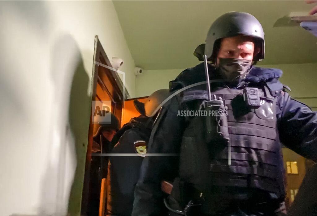 Mstyslav Chernov Police walk out from a door of the apartment where Oleg Navalny lives, brother of jailed opposition leader Alexei Navalny, in Moscow, Russia, Wednesday, Jan. 27, 2021. Police are searching the Moscow apartment of jailed Russian opposition leader Alexei Navalny, another apartment where his wife is living and two offices of his anti-corruption organization. Navalny's aides reported the Wednesday raids on social media. (AP Photo/Mstyslav Chernov)