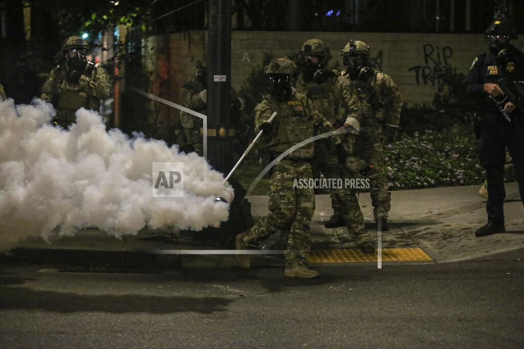 Dave Killen Police respond to protesters during a demonstration, Friday, July 17, 2020 in Portland, Ore. Militarized federal agents deployed by the president to Portland, fired tear gas against protesters again overnight as the city’s mayor demanded that the agents be removed and as the state’s attorney general vowed to seek a restraining order against them.(Dave Killen/The Oregonian via AP)