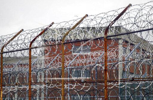 FILE - This March 16, 2011 file photo shows a barbed wire fence outside inmate housing on New York's Rikers Island correctional facility in New York. New York City’s notorious Rikers Island jail complex, troubled by years of neglect, has spiraled into turmoil during the coronavirus pandemic. (AP Photo/Bebeto Matthews, File)