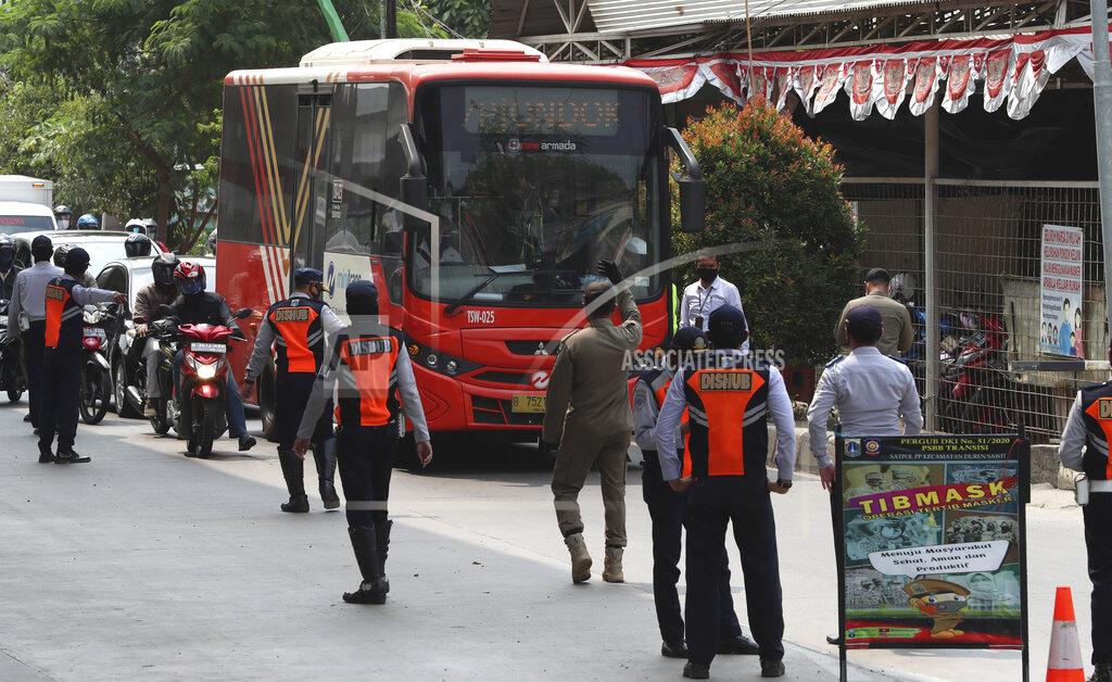 Achmad Ibrahim Officers stand guard at a police check point during the imposition of large-scale restriction to curb the spread of the coronavirus outbreak in Jakarta, Indonesia, Monday, Sept. 14, 2020. Indonesia's capital on Monday begins to reimpose large-scale social restrictions to control a rapid expansion in the virus cases. (AP Photo/Achmad Ibrahim)