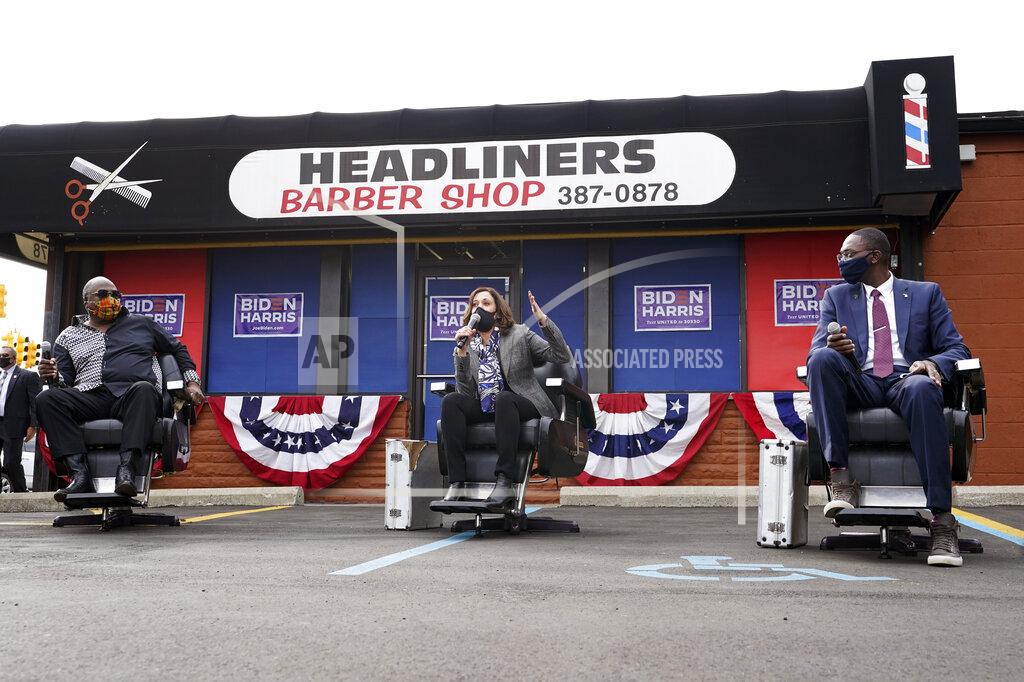 Paul Sancya Democratic vice presidential candidate Sen. Kamala Harris, D-Calif., speaks as Reverend Wendell Anthony, left, and Michigan Lt. Gov. Garlin Gilchrist II listen at Headliners Barbershop in Detroit, Tuesday, Sept. 22, 2020. (AP Photo/Paul Sancya)