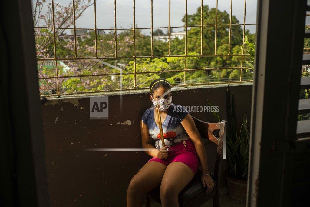 Ramon Espinosa Ana Laura Ramirez Lavandero, 10, poses or a portrait holding drumsticks on the balcony of her home in Havana, Cuba, on Friday, May 8, 2020. Ana Laura dreams of becoming a famous drummer. This was her first year at a highly selective institute for students identified early on as musically talented. She is continuing with classes in math, history and Spanish, but not music, during the COVID-19 coronavirus lockdown. (AP Photo/Ramon Espinosa)
