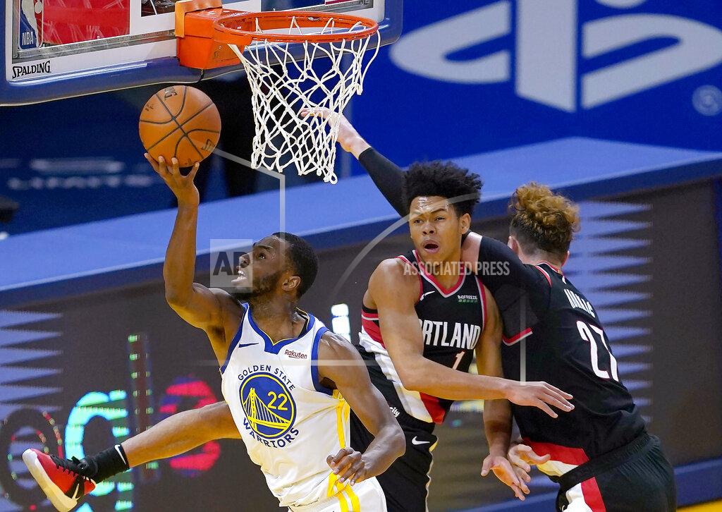 Tony Avelar Golden State Warriors forward Andrew Wiggins (22) drives to the basket between Portland Trail Blazers guard Anfernee Simons (1) and center Jusuf Nurkic (27) during the first half of an NBA basketball game in San Francisco, Friday, Jan. 1, 2021. (AP Photo/Tony Avelar)