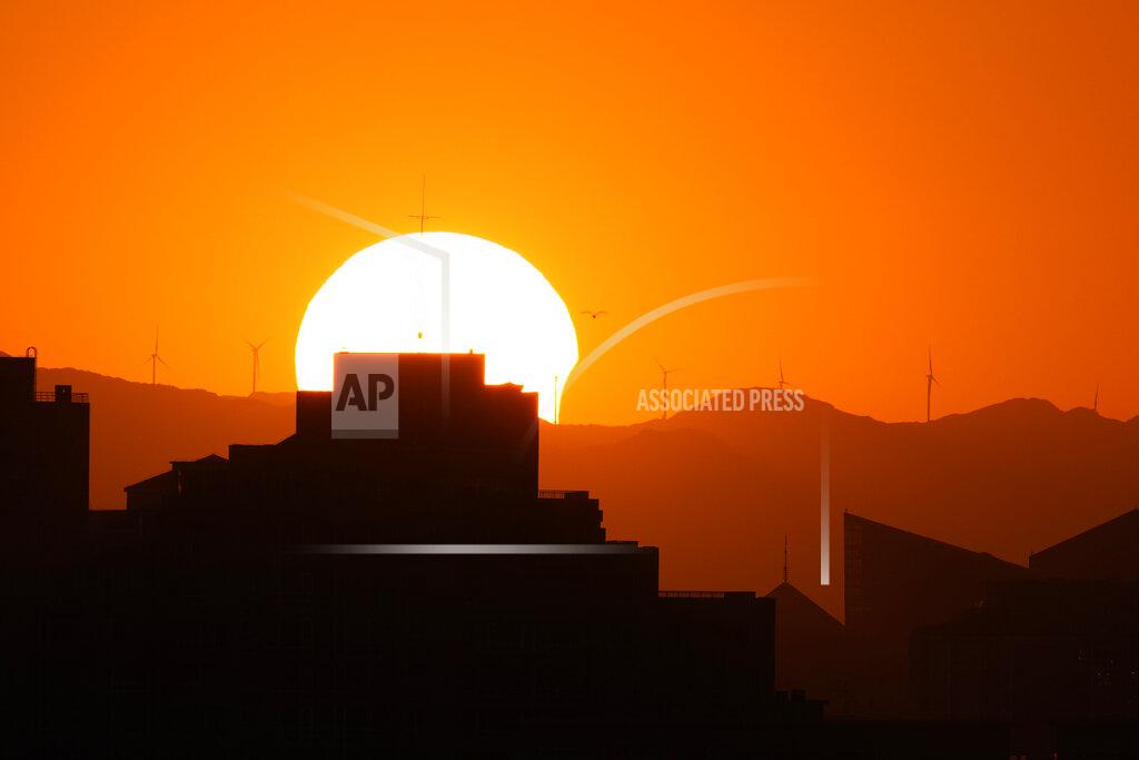 Ng Han Guan The sun is partially eclipsed as it sets over the horizon in Beijing on Thursday, June 10, 2021. (AP Photo/Ng Han Guan)
