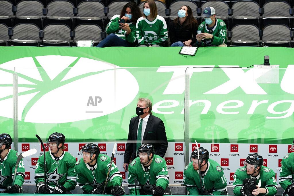 Tony Gutierrez Dallas Stars coach Rick Bowness stands behind players as fans sitting a distance away watch the first period of the team's NHL hockey game against the Nashville Predators in Dallas, Friday, Jan. 22, 2021. (AP Photo/Tony Gutierrez)
