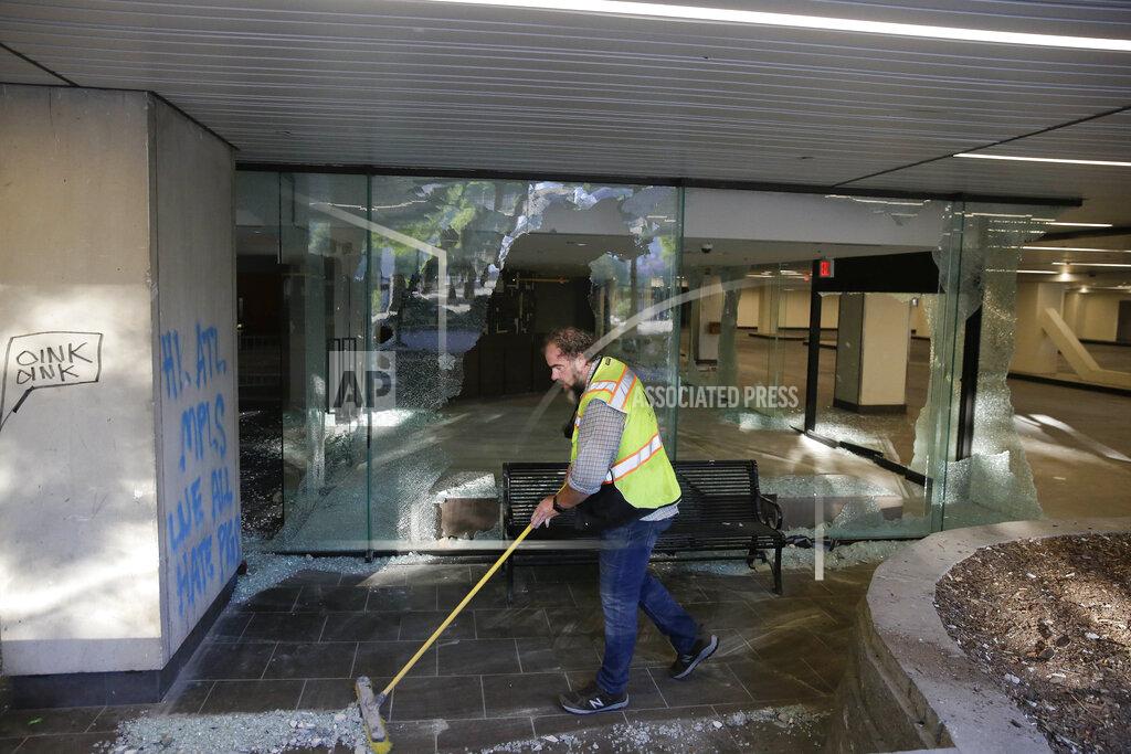 Brynn Anderson Bill Tracy, of Atlanta, cleans up glass in the aftermath of a demonstration against police violence on Saturday, May 30, 2020, in Atlanta. (AP Photo/Brynn Anderson)