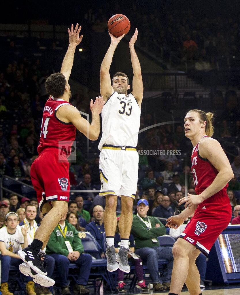 Robert Franklin Notre Dame's John Mooney (33) shoots a 3-pointer over North Carolina State's Devon Daniels, left, and Wyatt Walker during the first half of an NCAA college basketball game Saturday, Jan. 19, 2019, in South Bend, Ind. (AP Photo/Robert Franklin)