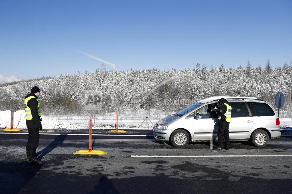 Petr David Josek Policemen check documents of a driver near the city of Sokolov, Czech Republic, Friday, Feb. 12, 2021. Almost 600 police officers were deployed to enforce a complete lockdown of the three hardest-hit counties on the border with Germany and Poland to help contain a fast-spreading variant of the coronavirus found in Britain. (AP Photo/Petr David Josek)
