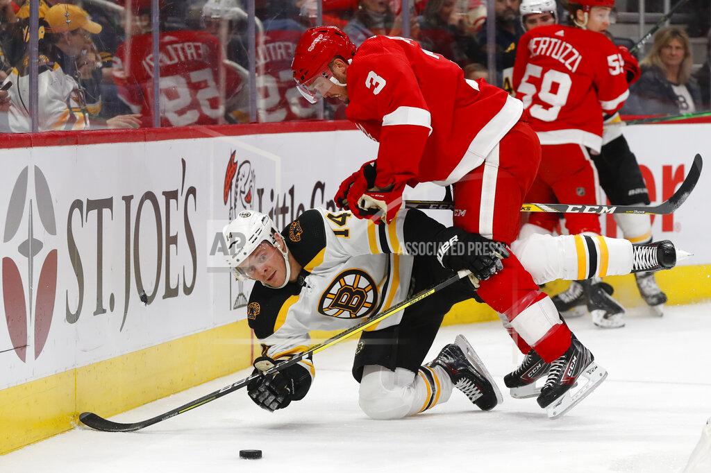Detroit Red Wings defenseman Alex Biega (3) checks Boston Bruins right wing Chris Wagner (14) off the puck in the first period of an NHL hockey game Sunday, Feb. 9, 2020, in Detroit. (AP Photo/Paul Sancya)