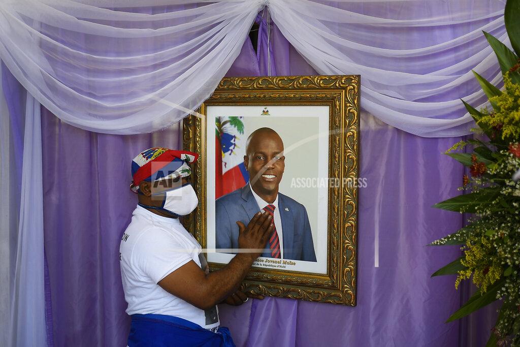 Matias Delacroix A man touches a portrait of the late Haitian President Jovenel Moïse outside the Cathedral where a memorial service for him takes place in Cap-Haitien, Haiti, Thursday, July 22, 2021. Moïse was killed in his home on July 7. (AP Photo/Matias Delacroix)