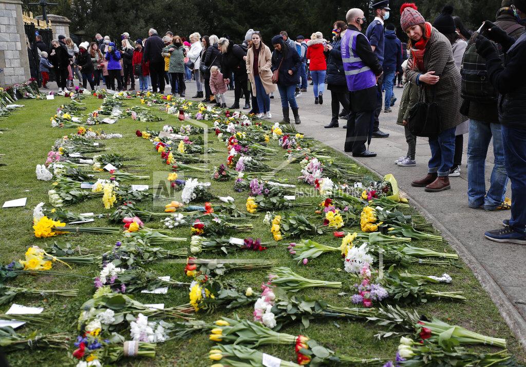 Frank Augstein People view flower tributes at Cambridge Gate, at Windsor Castle, one day after the death of Britain's Prince Philip, in Windsor, England, Saturday, April 10, 2021. Britain's Prince Philip, the irascible and tough-minded husband of Queen Elizabeth II who spent more than seven decades supporting his wife in a role that mostly defined his life, died on Friday. (AP Photo/Frank Augstein)