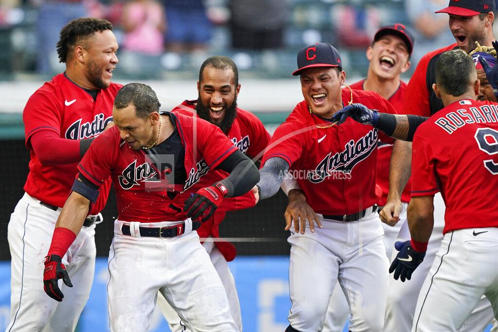 Tony Dejak Teammates mob Cleveland Indians' Cesar Hernandez, second from left, after Hernandez hit a two-run home run in the 10th inning of a baseball game against the Minnesota Twins, Saturday, May 22, 2021, in Cleveland. (AP Photo/Tony Dejak)