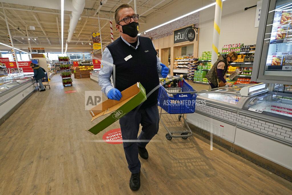 Kathy Willens In this Thursday, Feb. 4, 2021 photo, Lidl employee Joseph Lupo makes his rounds tidying up in the Long Island grocery store where he works in Lake Grove, N.Y. Earlier in the day, Lupo received the first dose of the COVID-19 vaccination at a Suffolk County Community College vaccination hub located in a giant arena repurposed for vaccinations. (AP Photo/Kathy Willens)