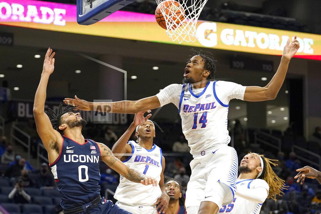 Charles Rex Arbogast DePaul's Nick Ongenda (14) blocks the shot of Connecticut's Jalen Gaffney (0) as Javan Johnson also defends during the first half of an NCAA college basketball game Saturday, Jan. 29, 2022, in Chicago. (AP Photo/Charles Rex Arbogast)