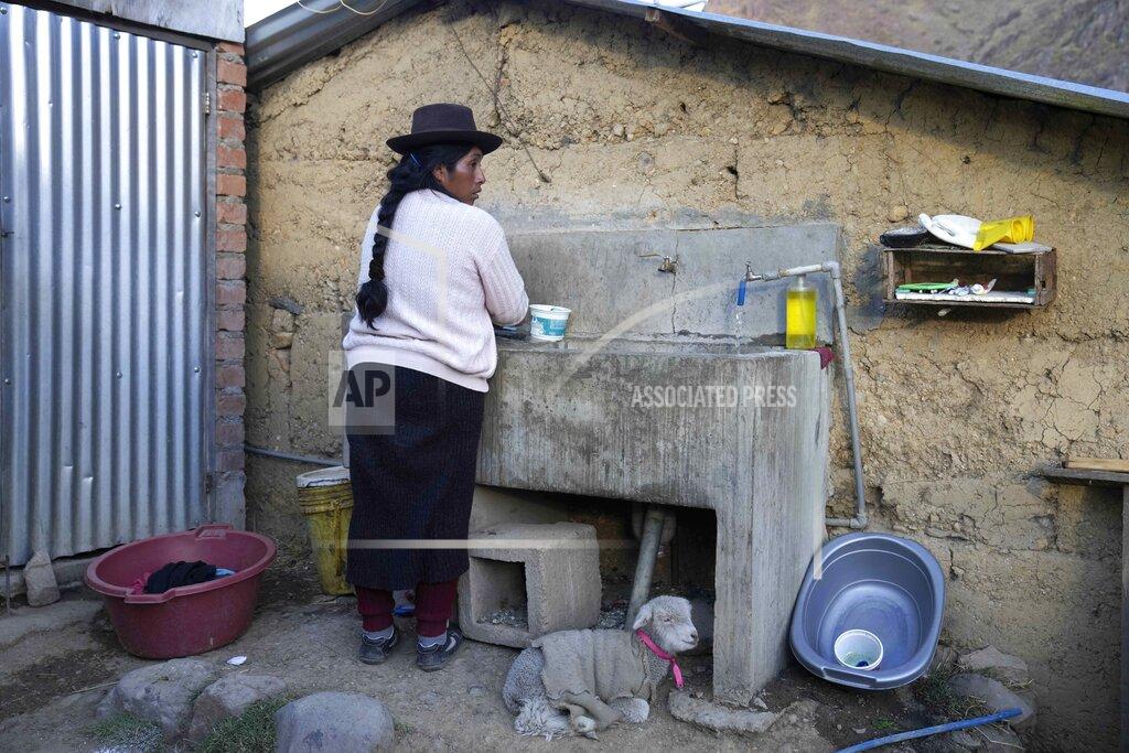 Martin Mejia Maribel Licapa, whose daughter is learning the Quechua Indigenous language at her public primary school, washes clothes at home in Licapa, Peru, Wednesday, Sept. 1, 2021. Licapa said that she was barred from speaking her native language when she worked at a plantation on Peru's coast and as a cleaner in the homes of wealthy families closer to her village. “You have to speak in Spanish. I don't understand,” one employer told her. (AP Photo/Martin Mejia)