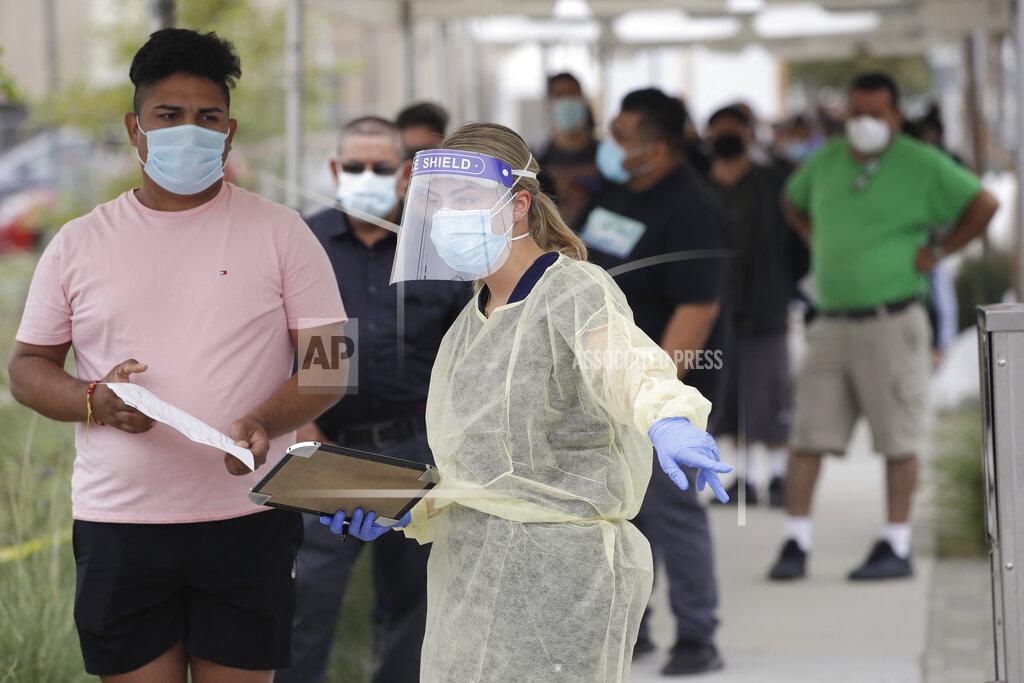FILE - In this July 22, 2020, file photo, people line up behind a health care worker at a mobile Coronavirus testing site at the Charles Drew University of Medicine and Science, in Los Angeles. As the world races to find a vaccine and a cure for COVID-19, there is seemingly no antidote in sight to the burgeoning outbreak of coronavirus conspiracy theories, hoaxes, anti-mask myths and sham treatments. (AP Photo/Marcio Jose Sanchez, File)