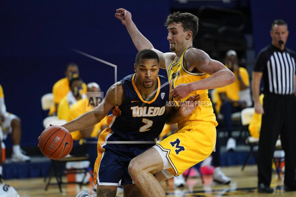 Paul Sancya Toledo forward Setric Millner Jr. (2) drives on Michigan guard Franz Wagner (21) in the first half of an NCAA college basketball game in Ann Arbor, Mich., Wednesday, Dec. 9, 2020. (AP Photo/Paul Sancya)