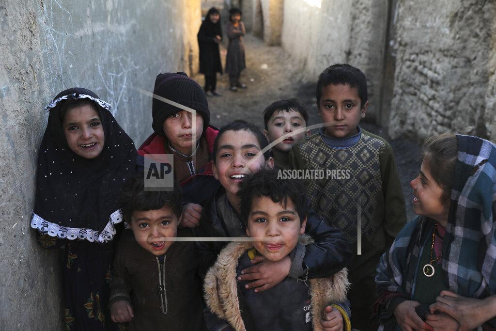 Rahmat Gul Internally displaced children pose for a photograph outside their temporary home in the city of Kabul, Afghanistan, Wednesday, Dec. 30, 2020. Save the Children has warned that more than 300,000 Afghan children face freezing winter conditions that could lead to illness, in the worst cases death, without proper winter clothing and heating. (AP Photo/Rahmat Gul)
