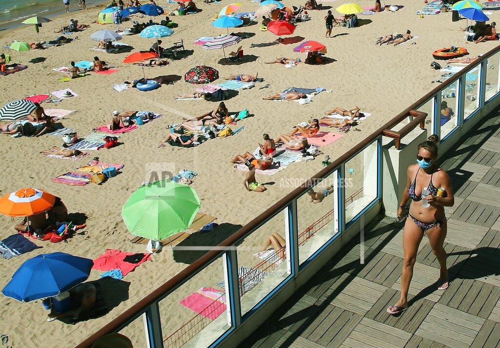 Bob Edme FILE - In this Wednesday, Aug. 5, 2020 file photo woman walks, wearing a face mask to protect against coronavirus, near the beach, in Saint Jean de Luz, southwestern France. The World Health Organization’s top official in Europe, Dr. Hans Kluge warned Thursday Aug. 27, 2020, that the coronavirus is a “tornado with a long tail” saying rising case counts among young people could ultimately spread the virus, and WHO issued advice to hotels as cases across Europe have increased amid the summer holiday season. (AP Photo/Bob Edme, File)
