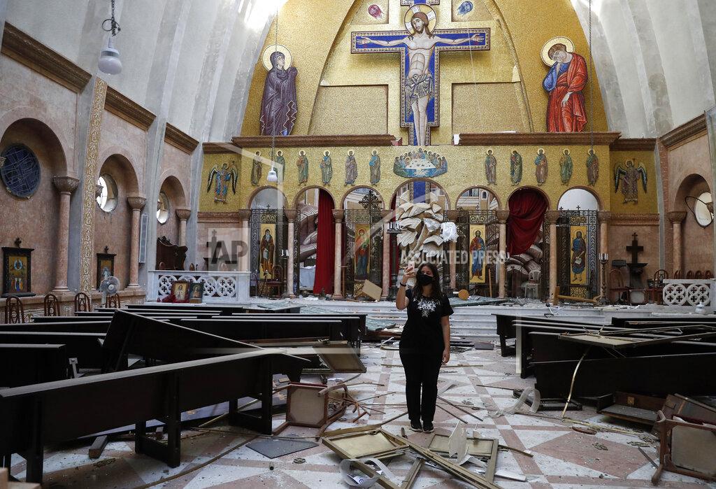 Hussein Malla A woman takes pictures by her mobile phone for a damaged church, after an explosion hit the seaport of Beirut, Lebanon, Wednesday, Aug. 5, 2020. Residents of Beirut awoke to a scene of utter devastation on Wednesday, a day after a massive explosion at the port sent shock waves across the Lebanese capital. (AP Photo/Hussein Malla)