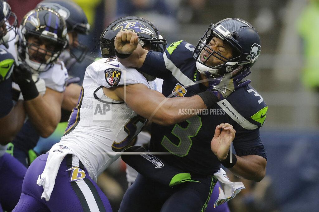 John Froschauer Seattle Seahawks quarterback Russell Wilson (3) is hit after he passed under pressure from Baltimore Ravens linebacker L.J. Fort, left, during the first half of an NFL football game, Sunday, Oct. 20, 2019, in Seattle. (AP Photo/John Froschauer)
