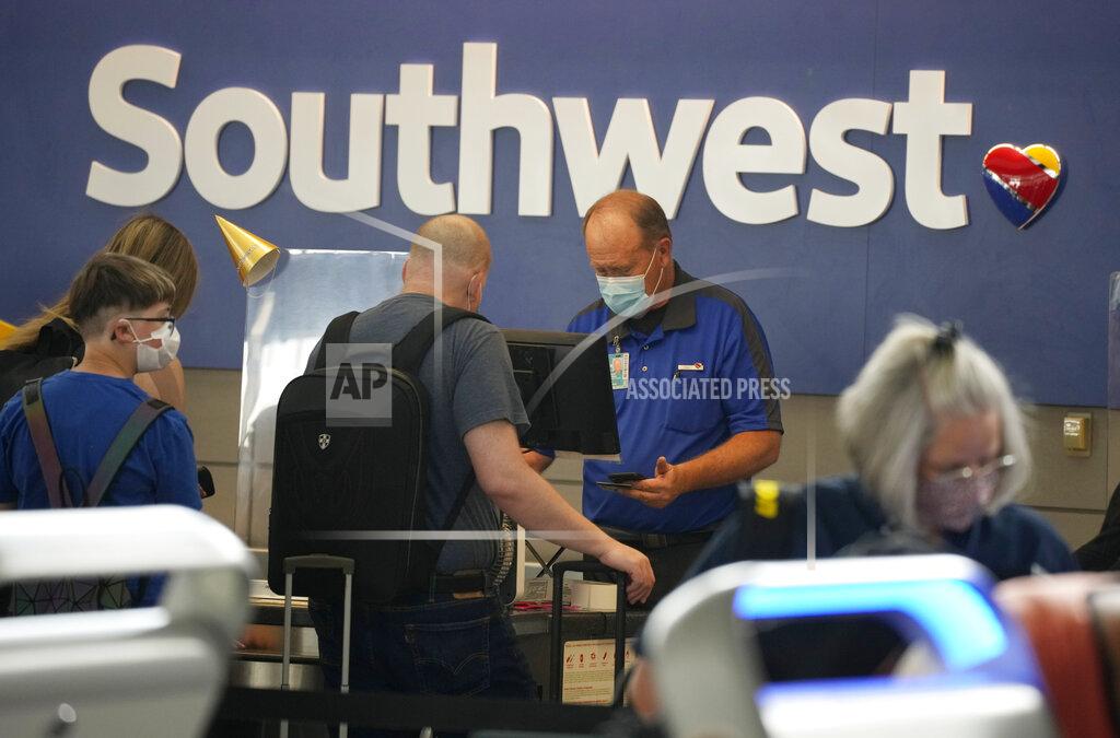 David Zalubowski FILE - In this Wednesday, June 16, 2021, file photo, a Southwest Airlines ticketing agent helps a traveller at the check-in counter at Denver International Airport in Denver. Southwest Airlines plans to raise minimum pay to $15 an hour for about 7,000 employees, citing the need to attract and keep workers as the airline industry continues to recover from the pandemic. Southwest said Friday, June 25, that it intends for the raises to take effect on Aug. 1. (AP Photo/David Zalubowski, File)
