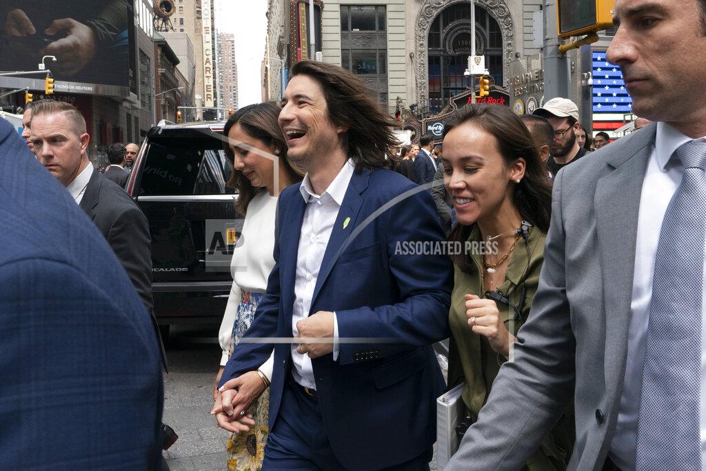 Mark Lennihan Vladimir Tenev, CEO and co-founder of Robinhood, center, walks in New York's Times Square following his company's IPO, Thursday, July 29, 2021. Robinhood is selling its own stock on Wall Street, the very place the online brokerage has rattled with its stated goal of democratizing finance. Through its app, Robinhood has introduced millions to investing and reshaped the brokerage industry, all while racking up a long list of controversies in less than eight years. (AP Photo/Mark Lennihan)