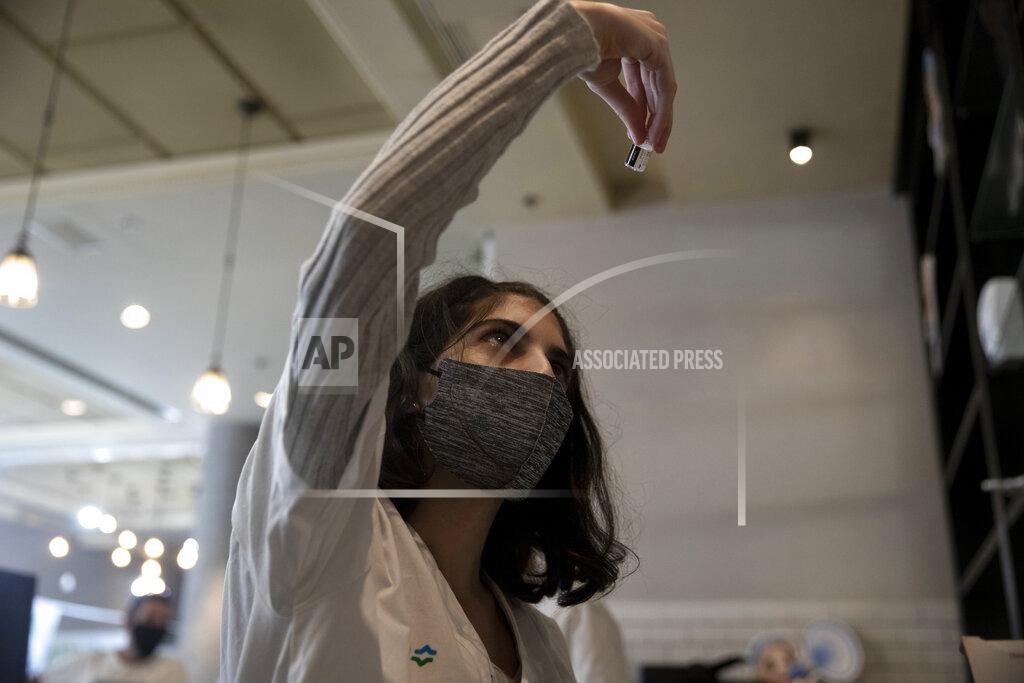 Maya Alleruzzo A medical worker prepares a vial of the Pfizer coronavirus vaccine at Clalit Health Service's vaccination center in the Cinema City complex in Jerusalem, Wednesday, Sept. 22, 2021. Israel is pressing ahead with its aggressive campaign of offering coronavirus boosters to almost anyone over 12 and says its approach was further vindicated by a U.S. decision to give the shots to older patients or those at higher risk. (AP Photo/Maya Alleruzzo)