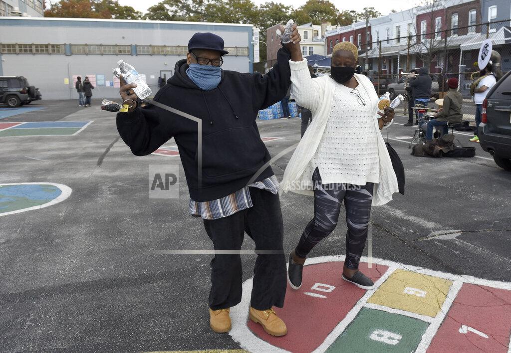 Michael Perez Louis Harris, left, and his wife Jean dance to the music of Lucky Chops and Snack Time in the parking lot of the Global Leadership Academy where they cast their votes on Election Day, Tuesday, Nov. 3, 2020, in Philadelphia. (AP Photo/Michael Perez)