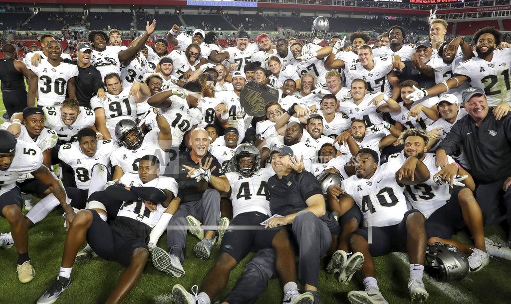 Mike Carlson Central Florida celebrates with the War on I-4 trophy after defeating South Florida in an NCAA college football game Friday, Nov. 23, 2018, in Tampa, Fla. (AP Photo/Mike Carlson)